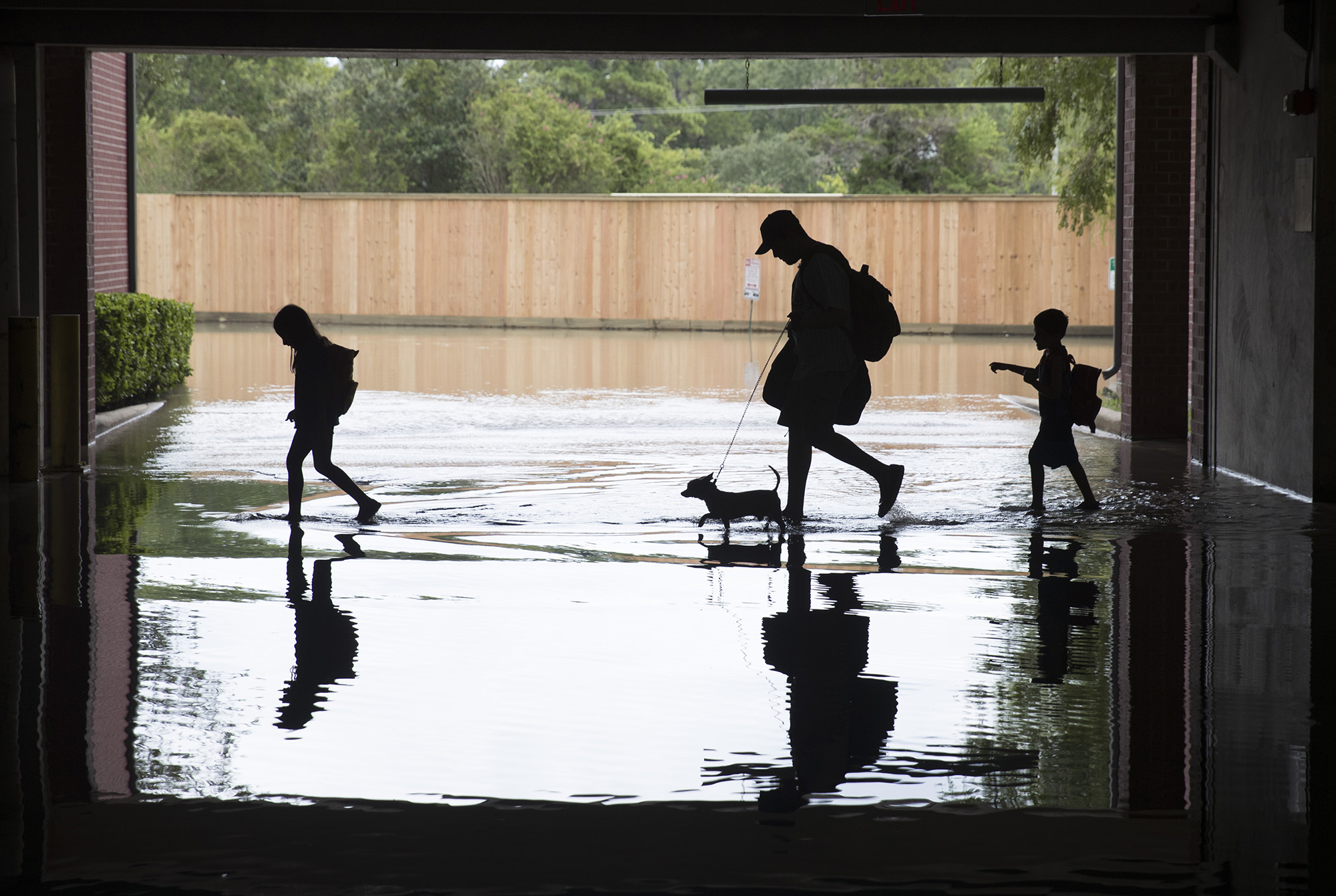 A family moves through a flooded garage