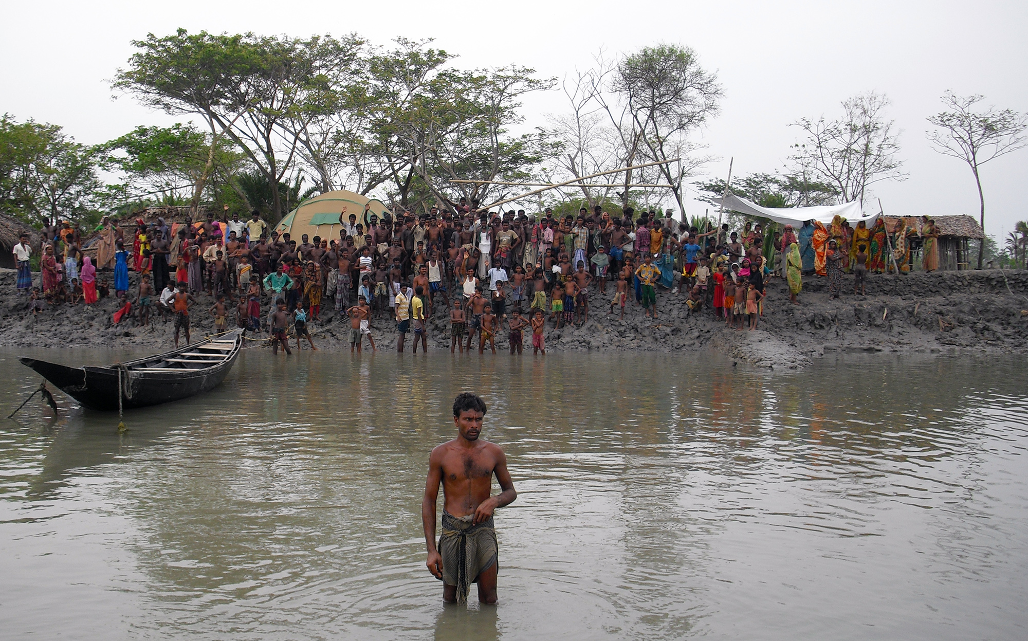 People waiting for aid at the riverbank