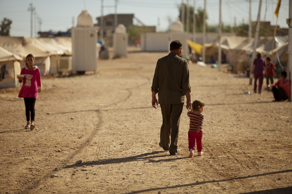 Father taking his son for a walk through their camp