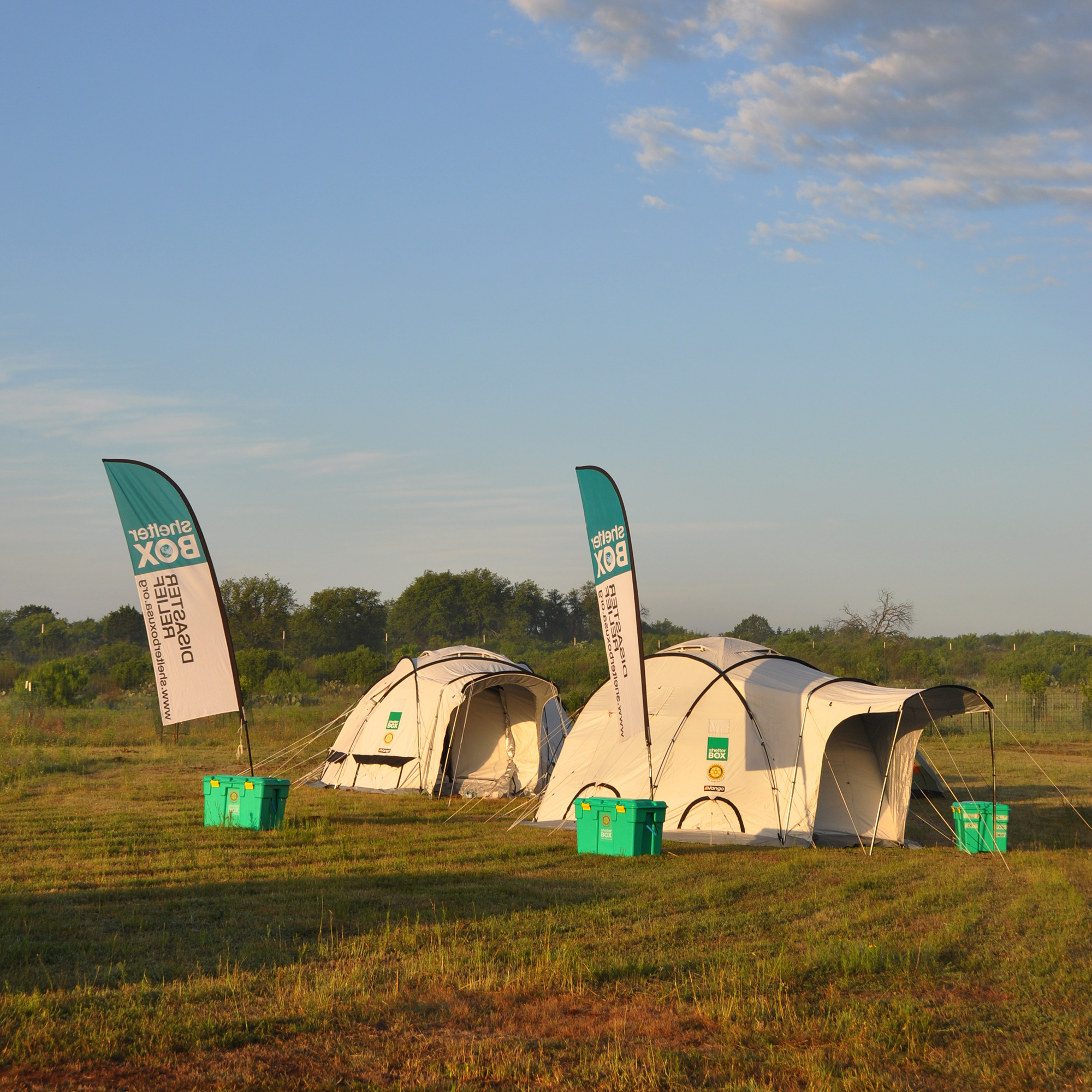 SAFE tents in front of a verdant landscape