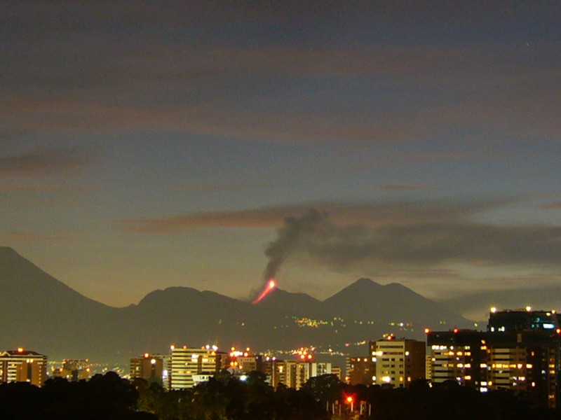 City skyline with erupting volcano in background