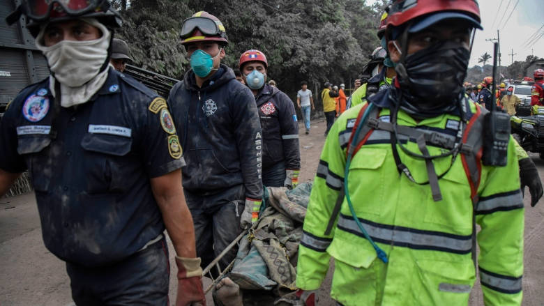 Police officers carry a victim of the eruption