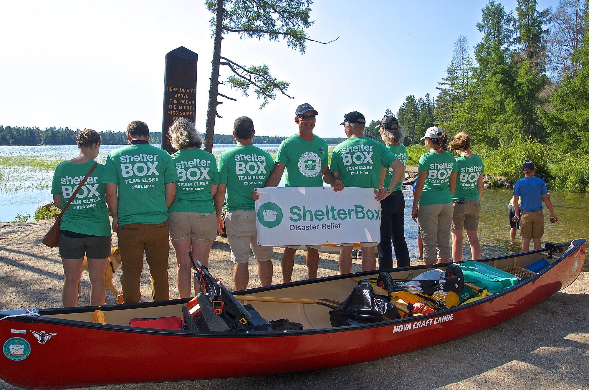 Erik with banner next to canoe