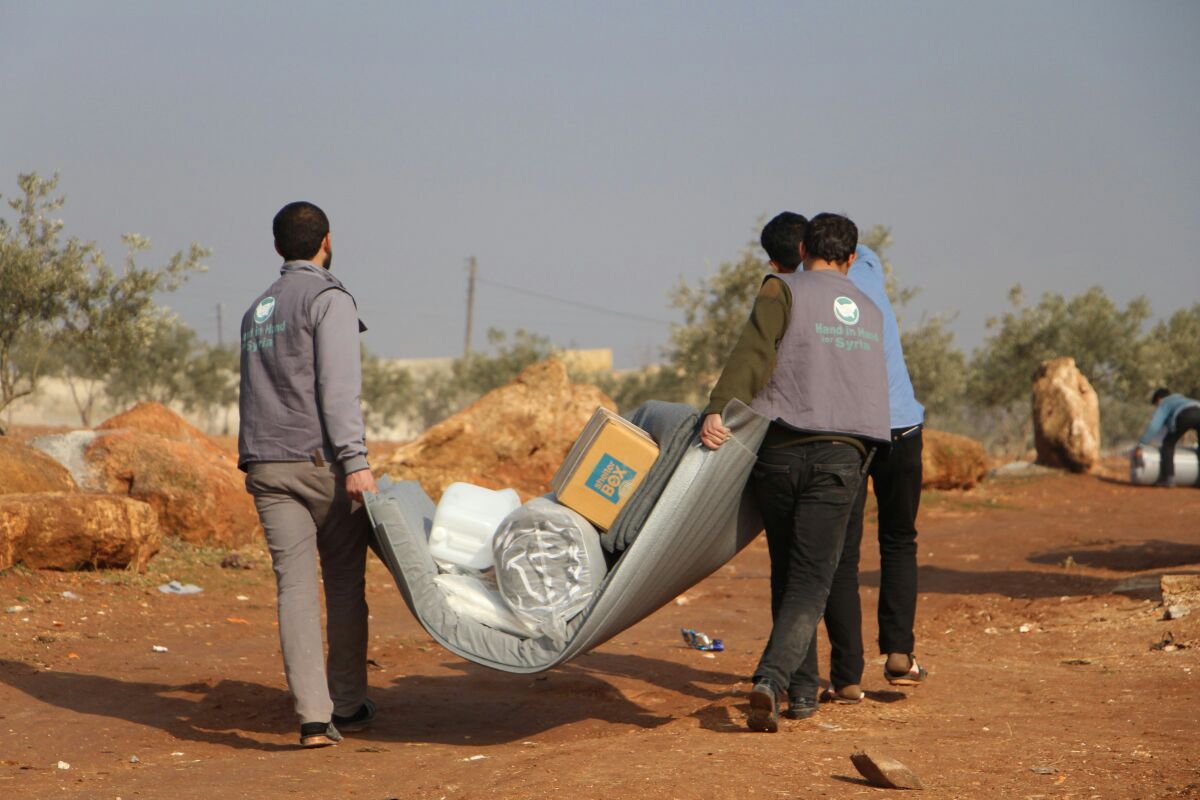 Working together to carry aid items across the dry landscape