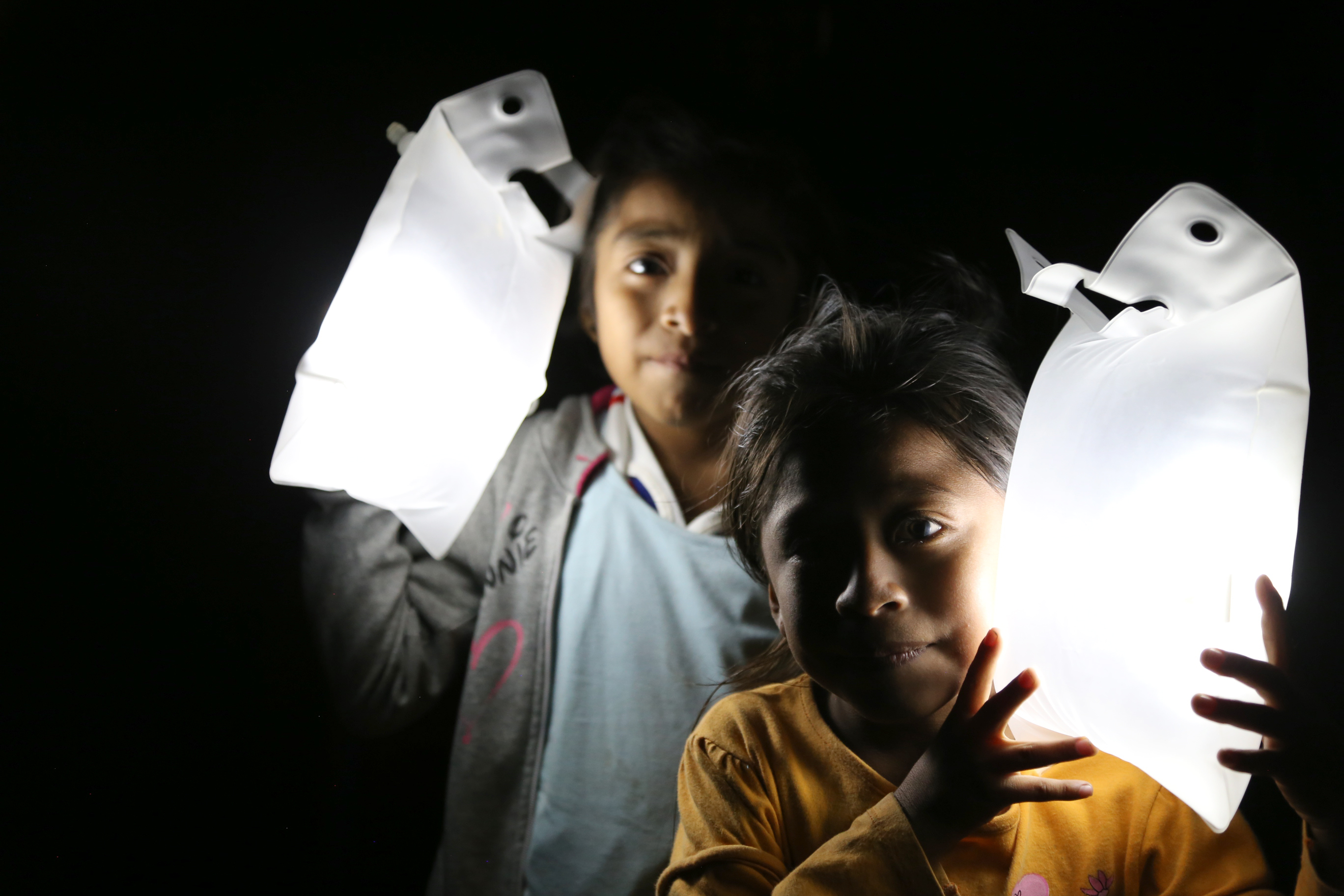Two children light up the night in the dark