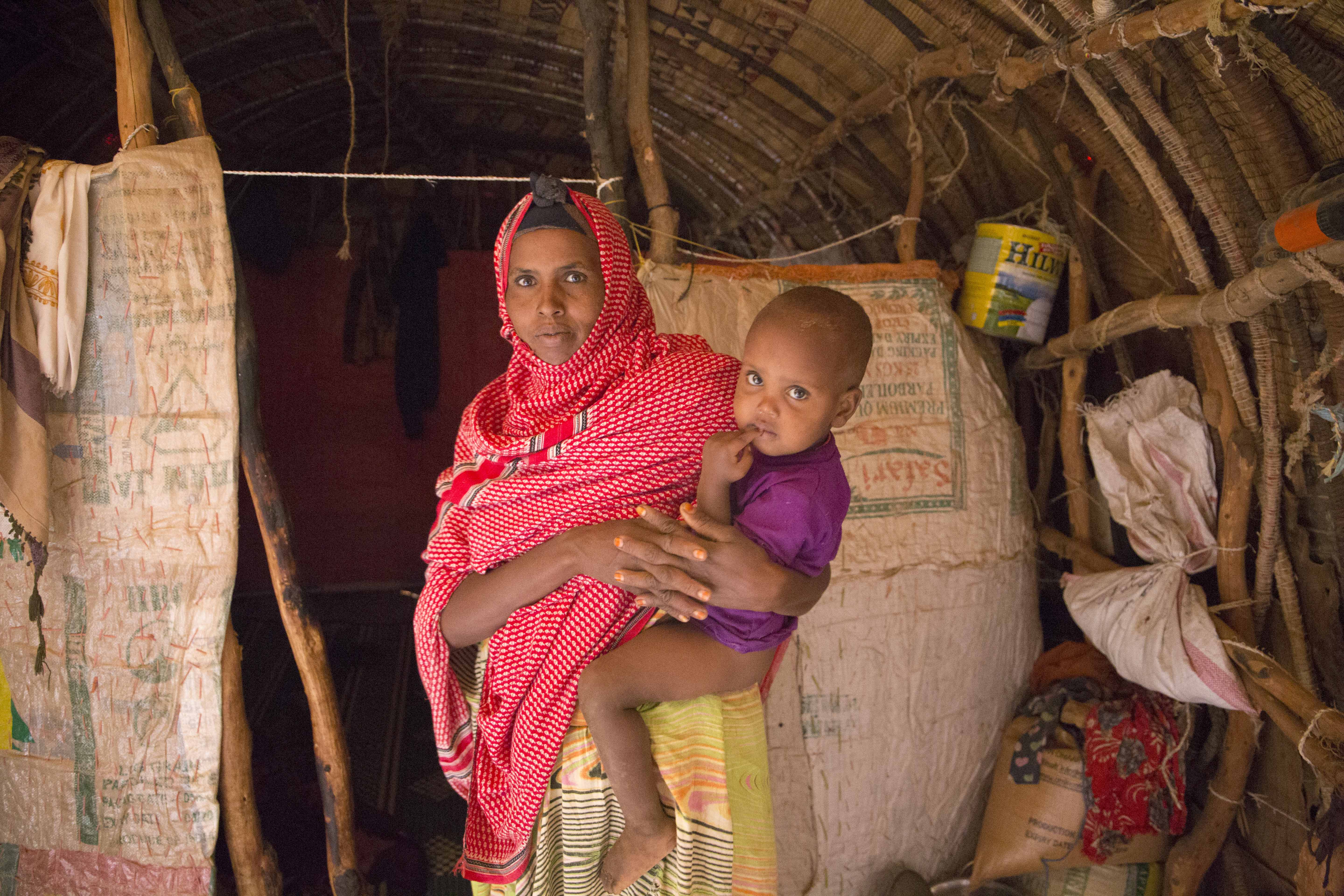 Muna and her child in their home