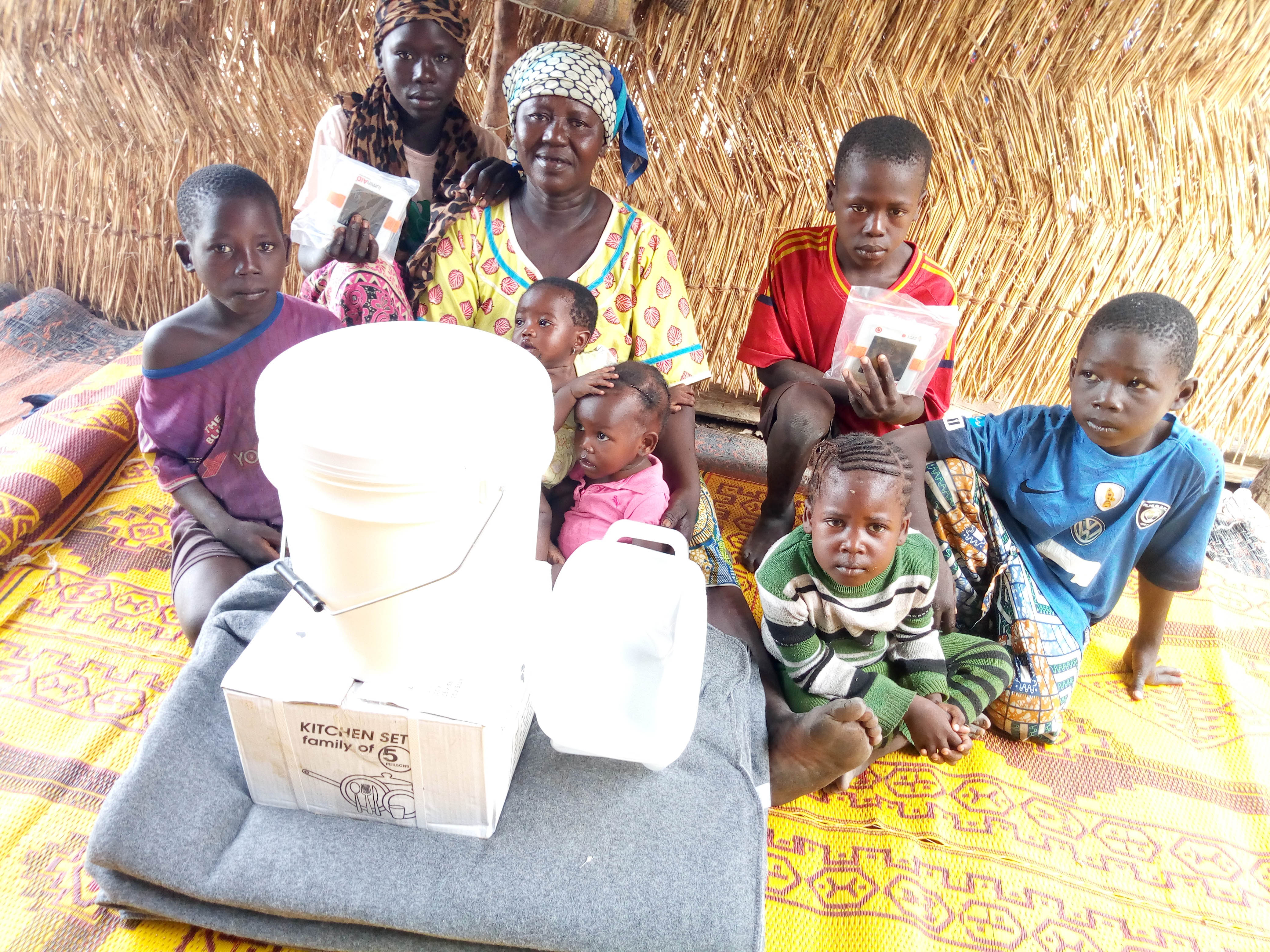 Atta and kids with water carrier, blanket, and kitchen set