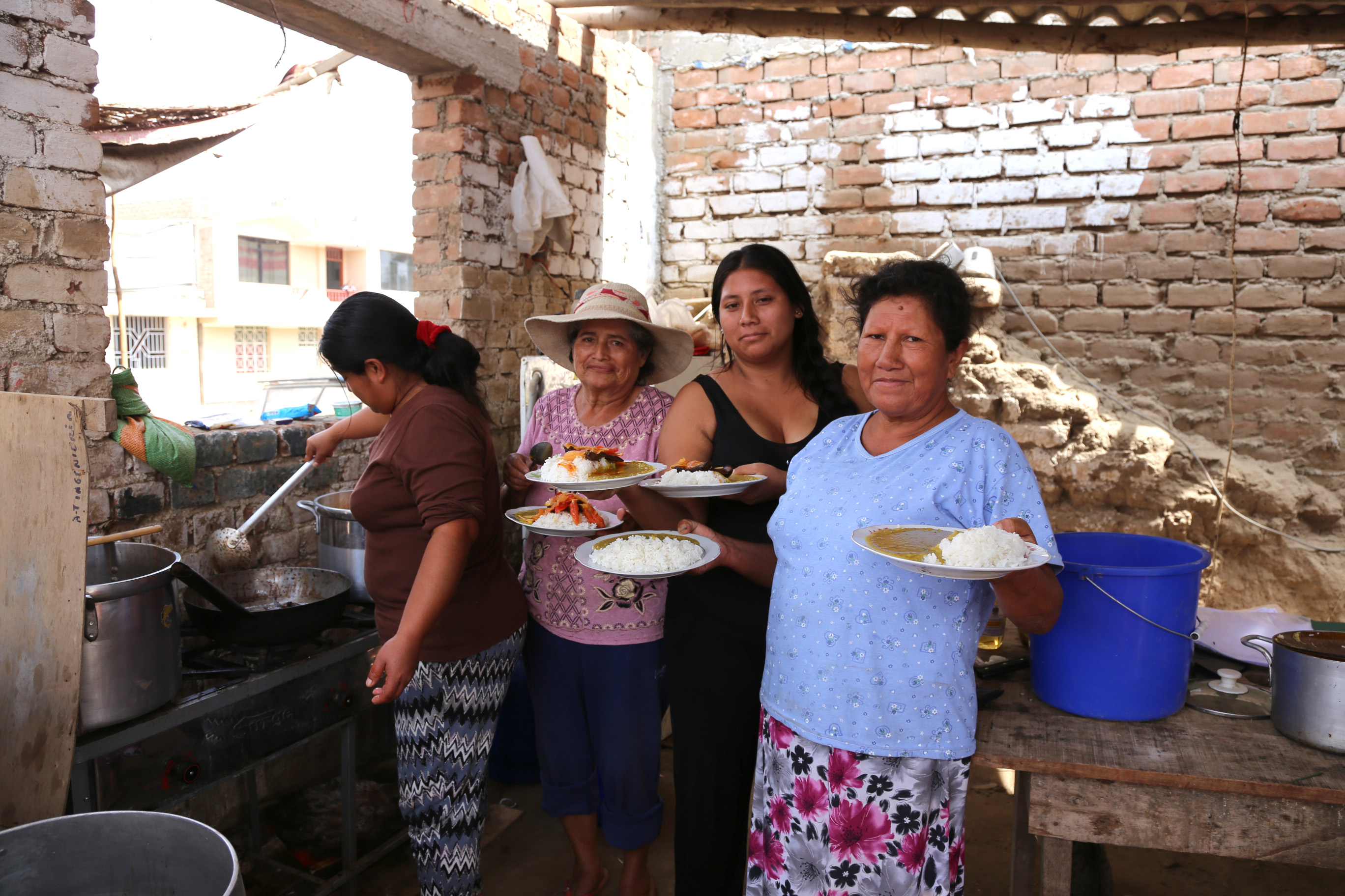 Yolanda and friends holding up 5 plates of food