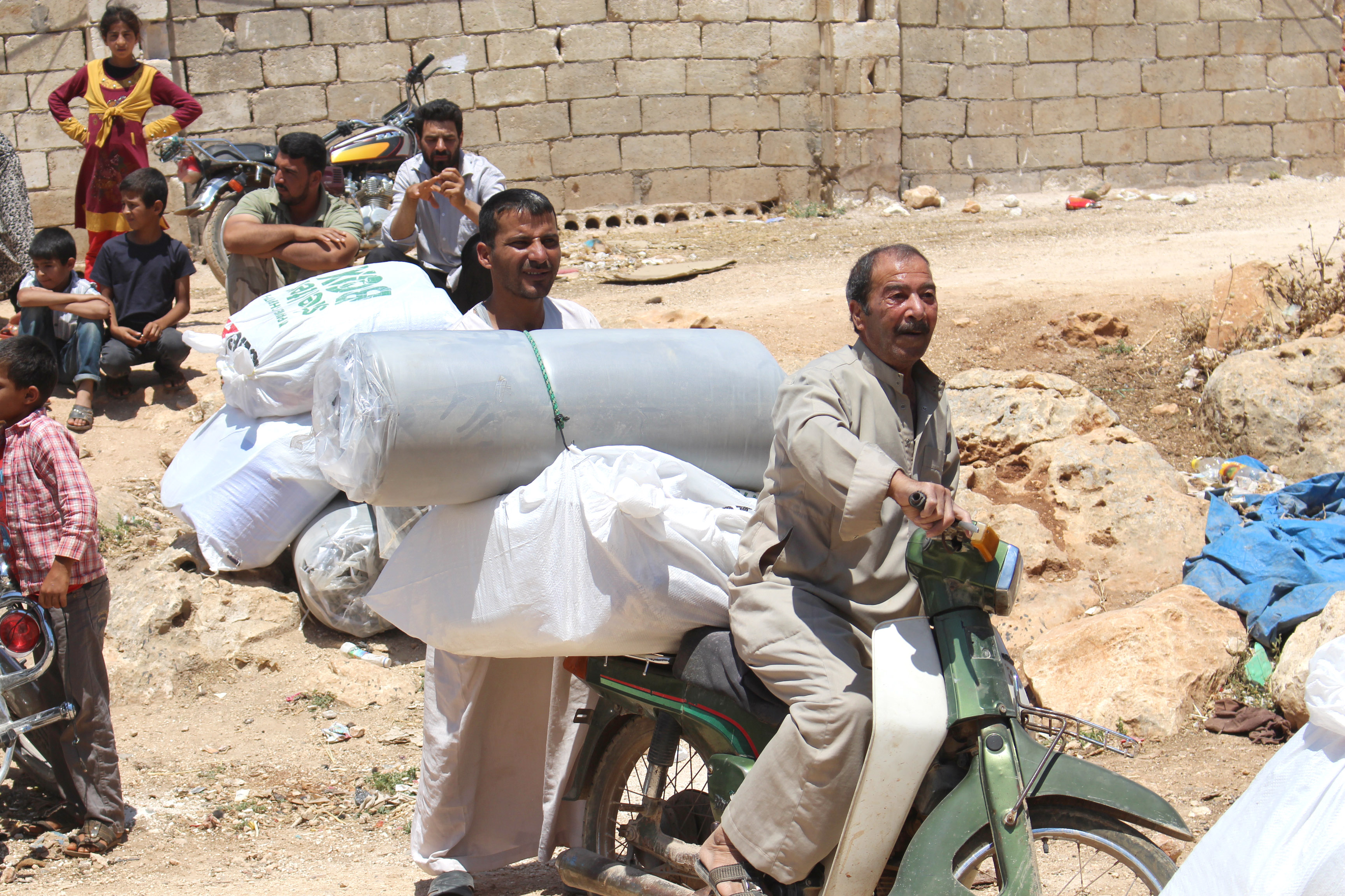 Carrying a tarpaulin and other aid items by motorcycle