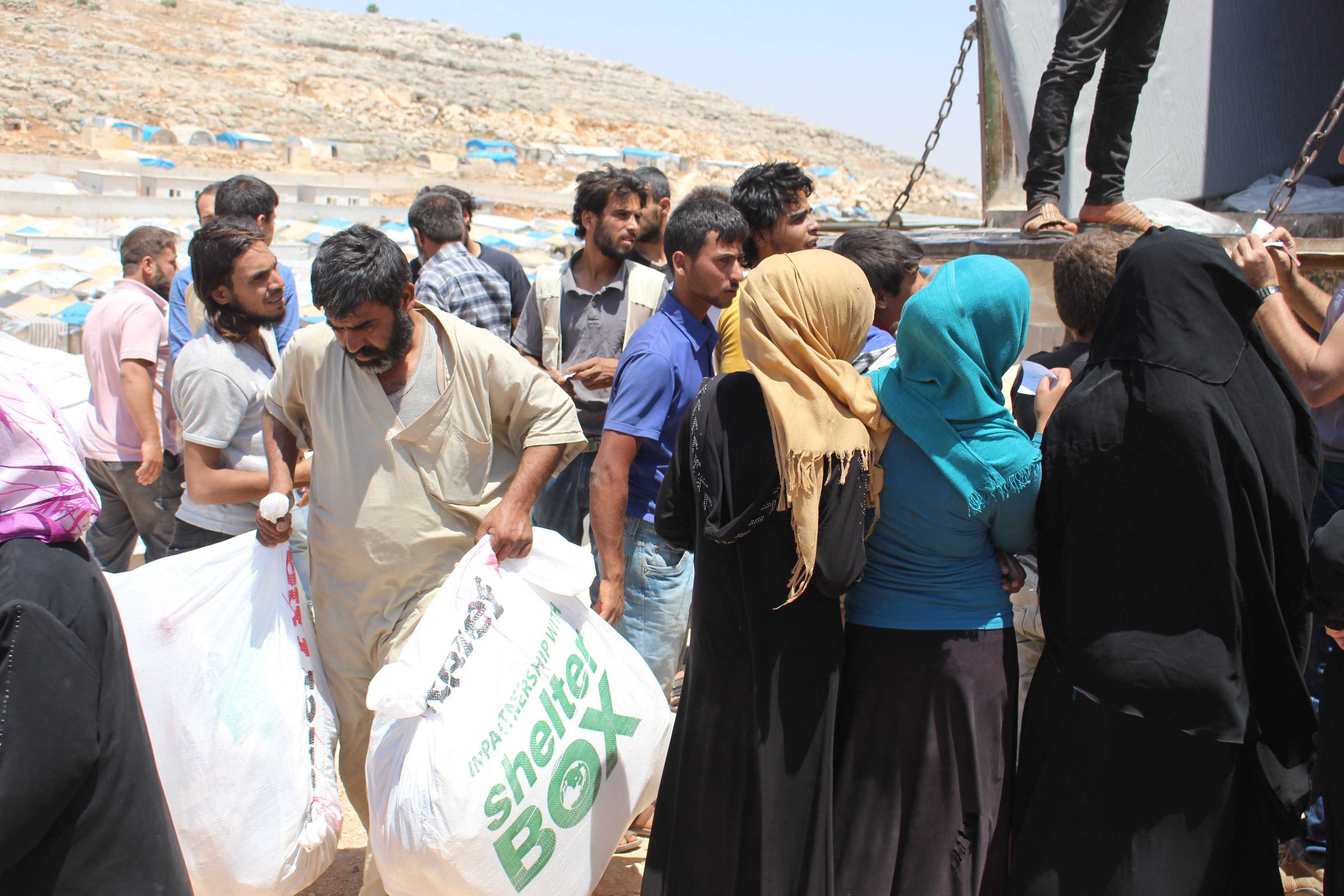 People gather around the truck to receive aid