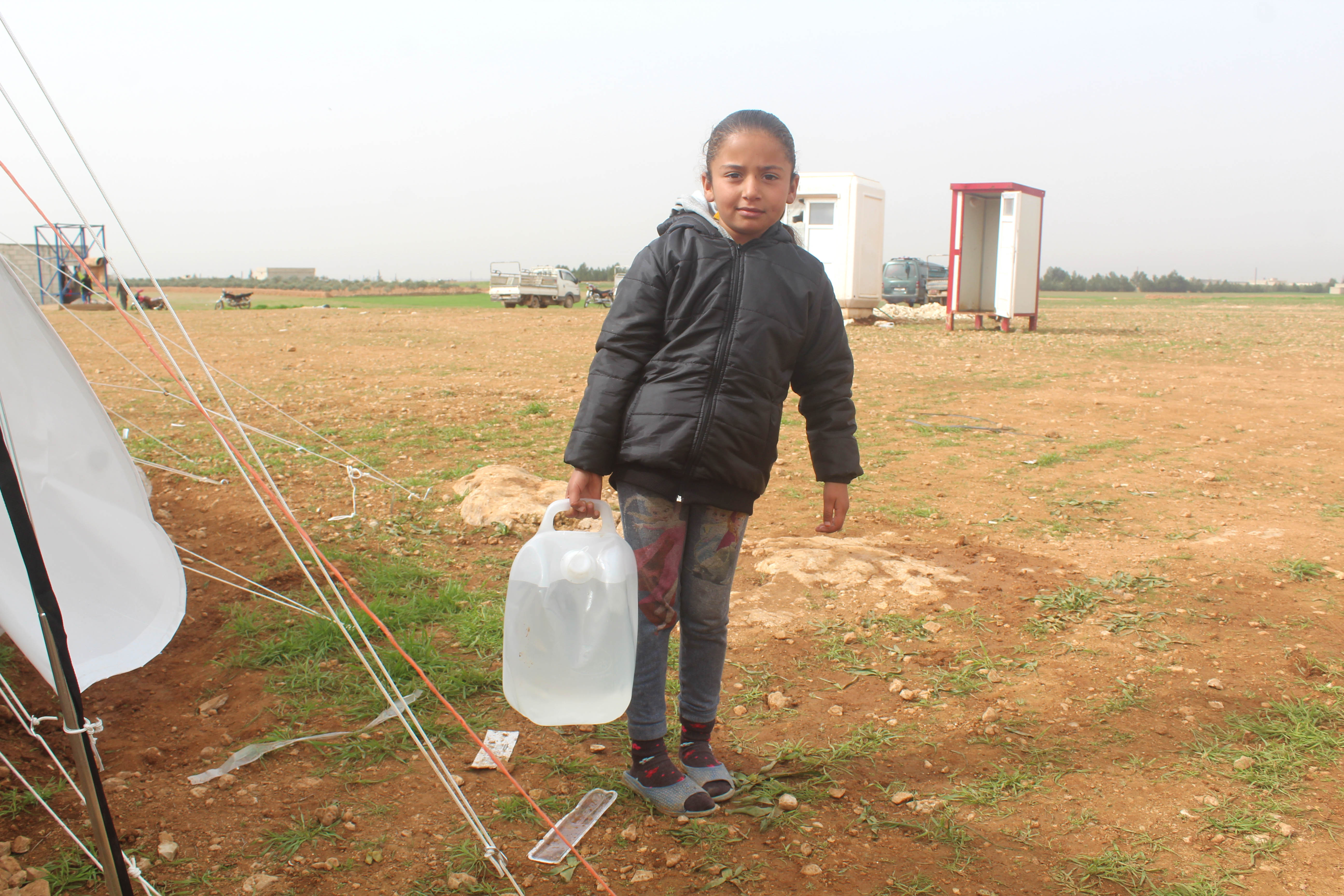 Young girl carrying a full water carrier