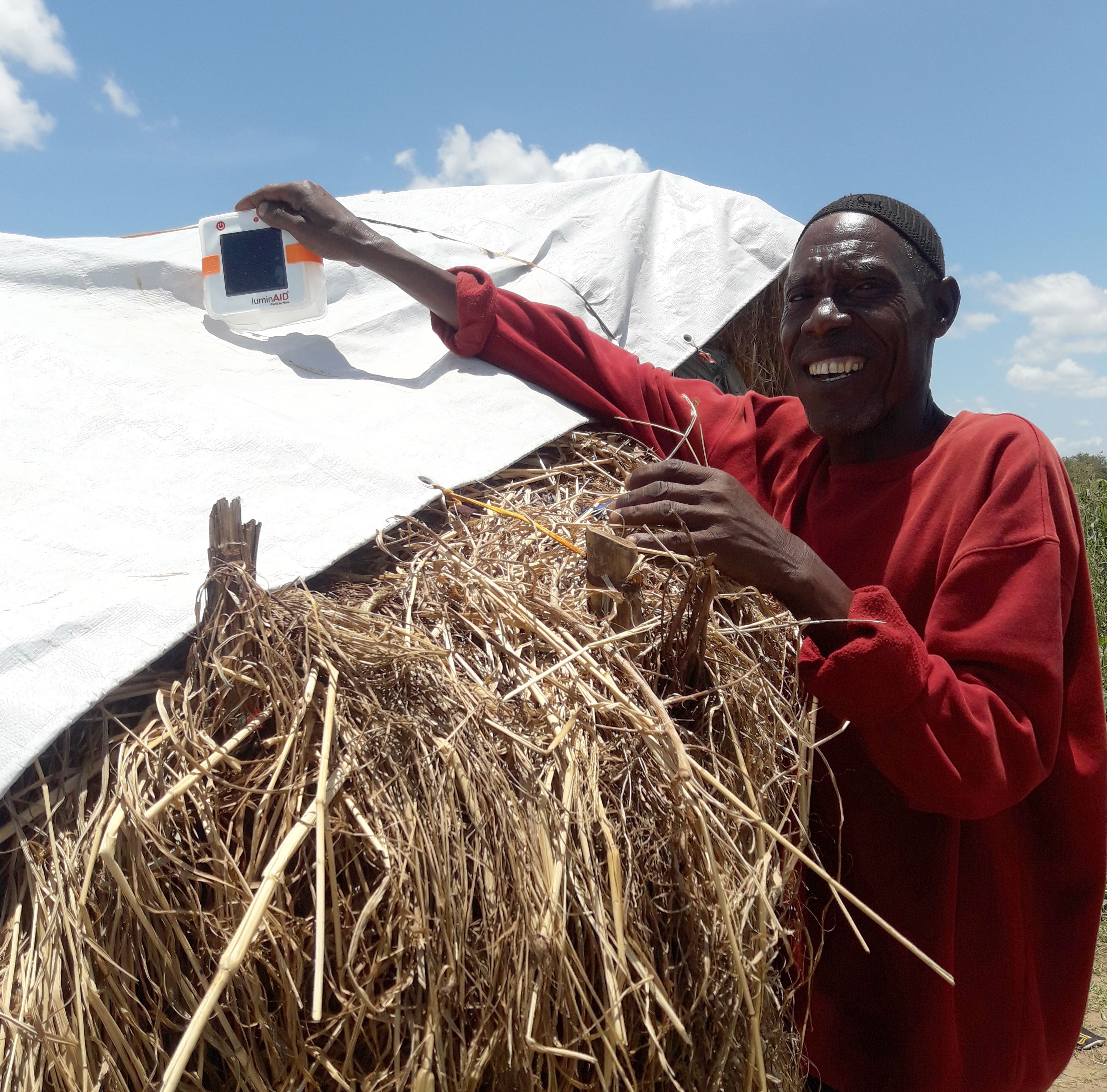 Cattle farmer cheerfully charging his Luminaid light during the day
