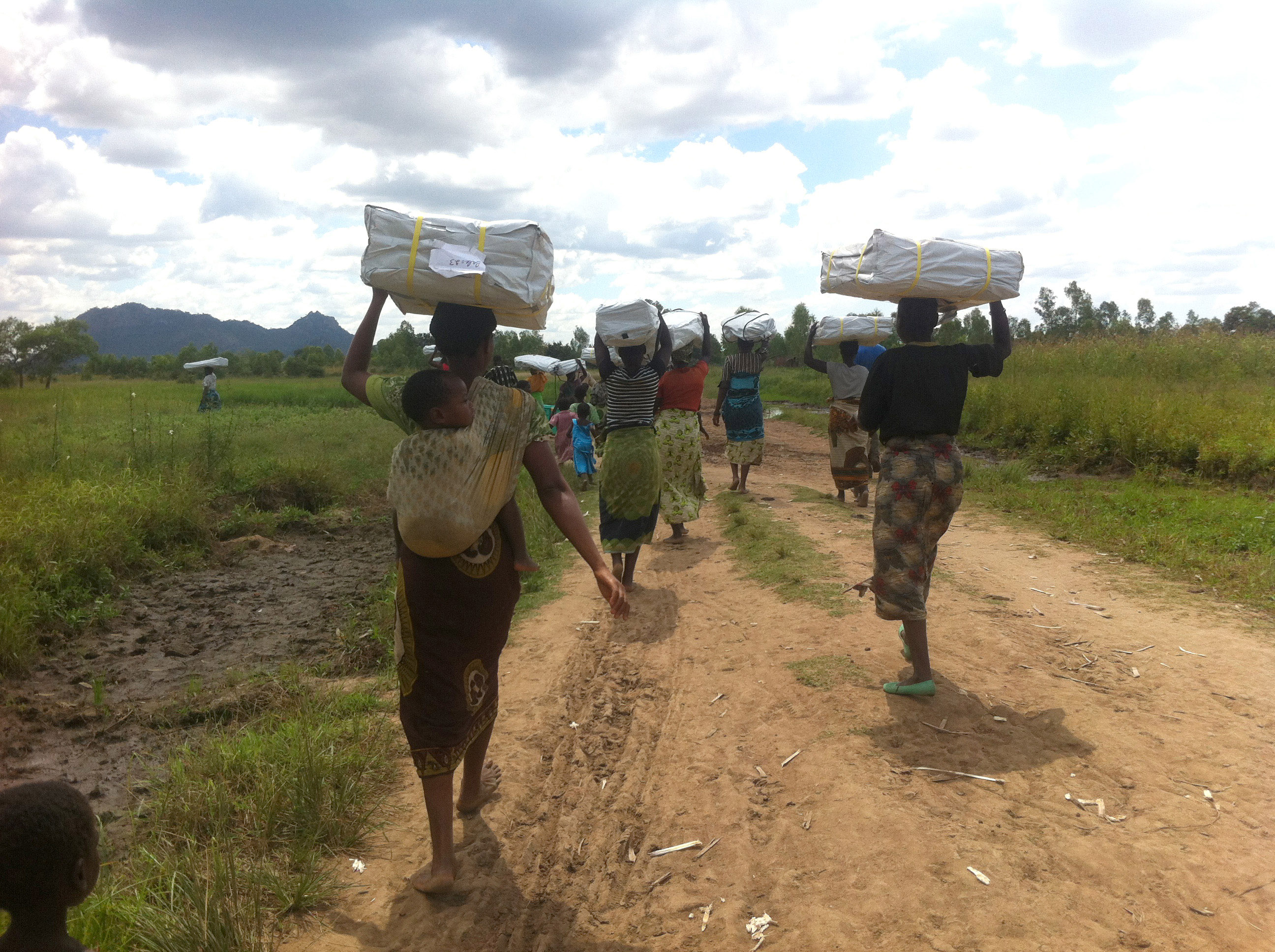 Women holding tarpaulins after flooding, Malawi