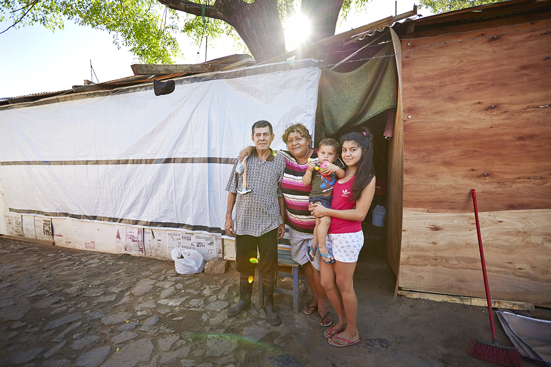 Family standing outside their repaired home