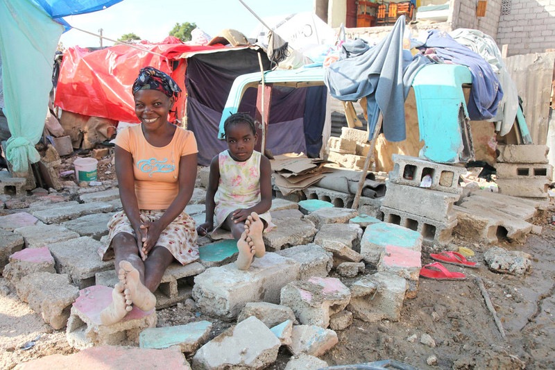 Mother and daughter sit among rubble, Haiti 2010.