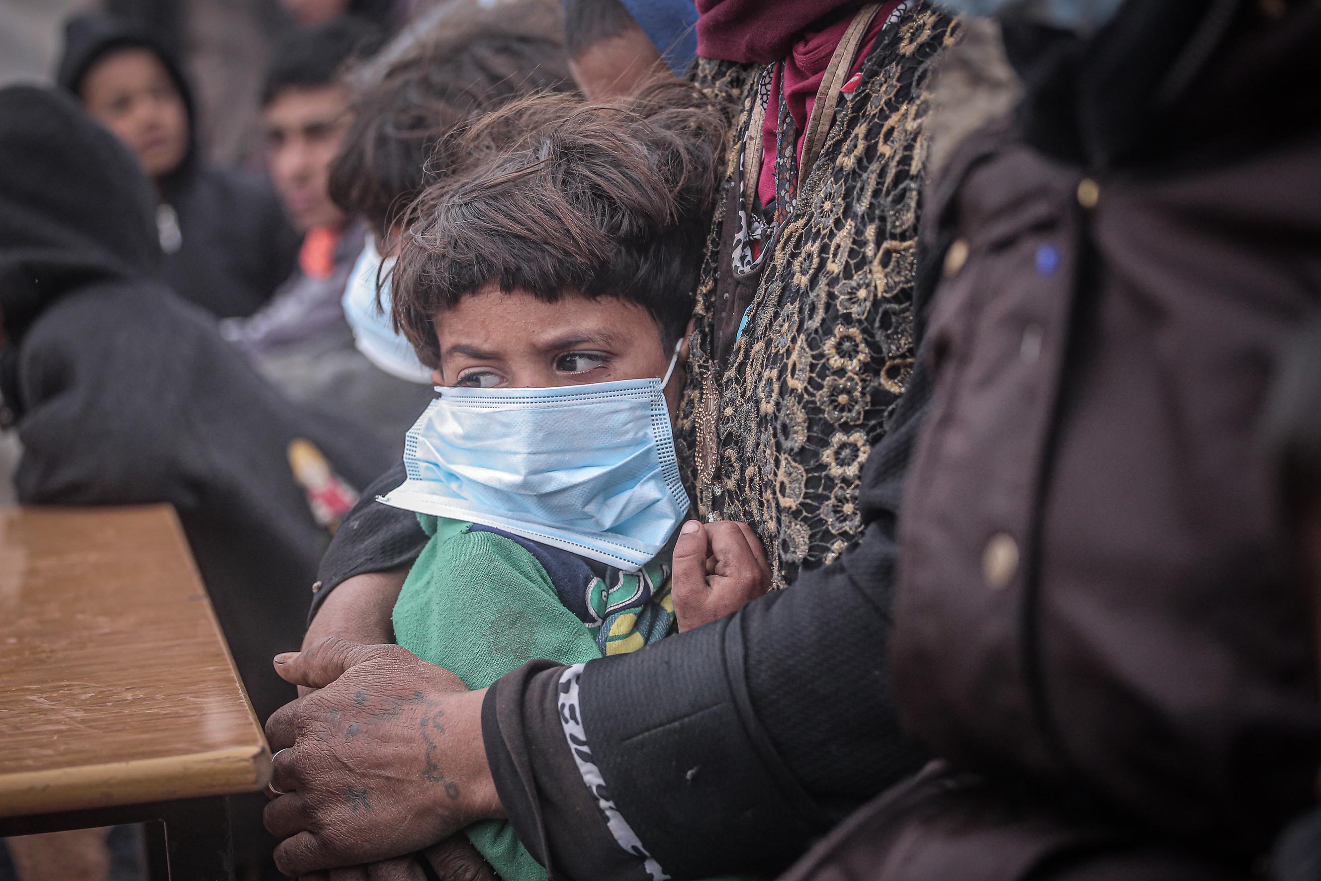 IDLIB, SYRIA - MARCH 18 : A child wears a mask as a preventive measure against coronavirus (Covid-19) as Idlib Health Directorate and Civil Defense Crews along with local charities carry out disinfection works at schools and tent cities in Idlib, Syria on March 18, 2020. (Photo by Muhammed Said/Anadolu Agency via Getty Images)