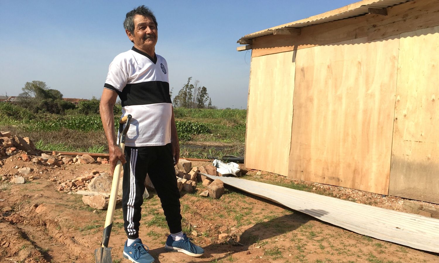 Cecilio poses alongside his newly built home