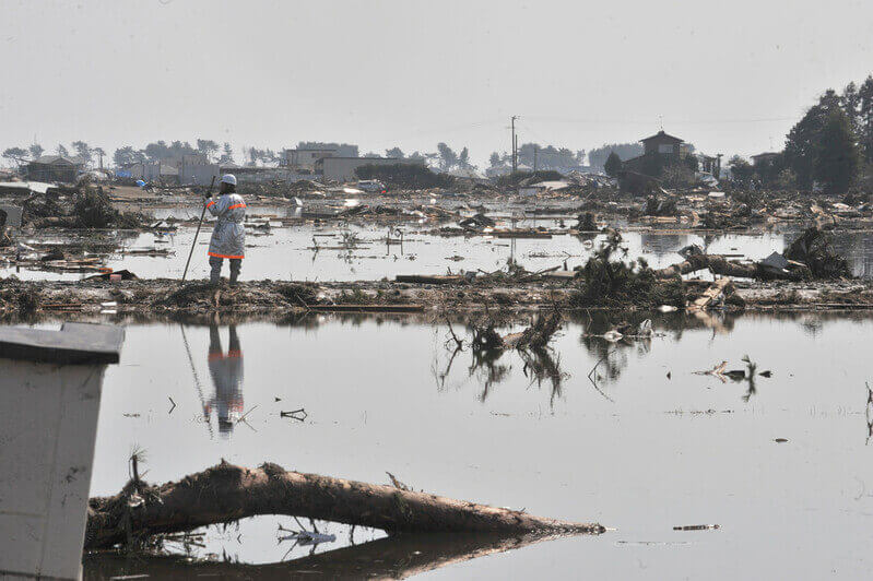 Aid worker gazing across the waterlogged landscape