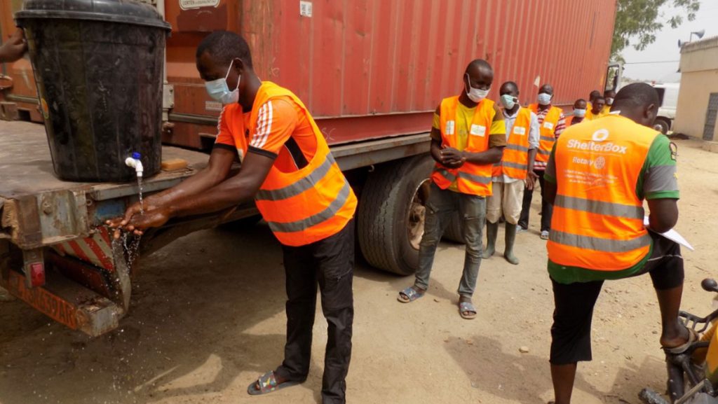 Volunteers in Cameroon washing their hands and keeping their distance