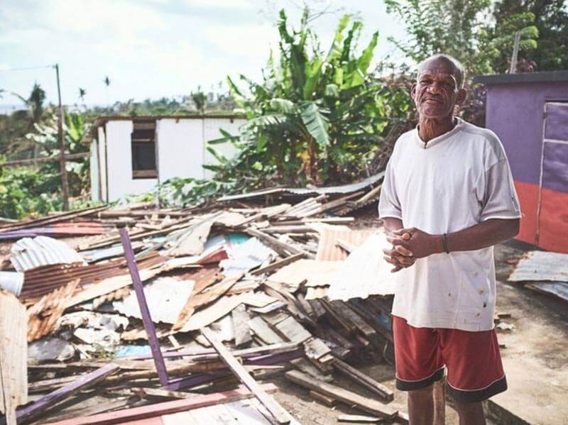 Man standing next to what used to be his home