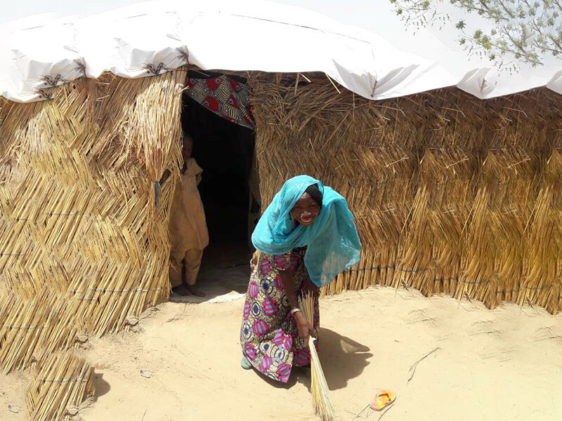 Falmata enjoying herself outside a structure with a roof using the ShelterBox tarpaulin