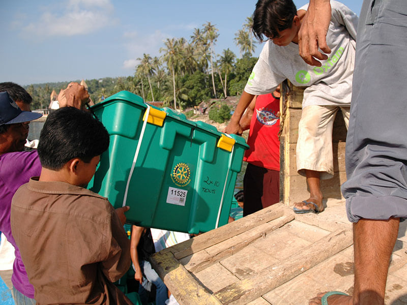 People helping each other take ShelterBoxes off a truck