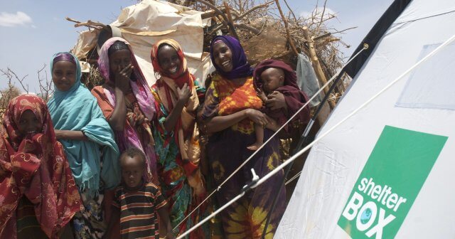 Women pose near Tent