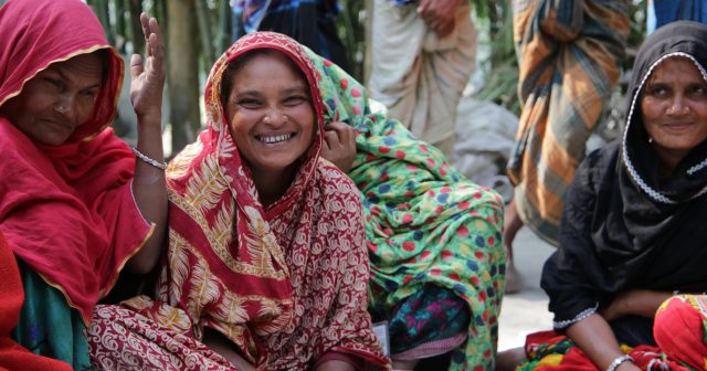 Women huddle together in a crowded camp