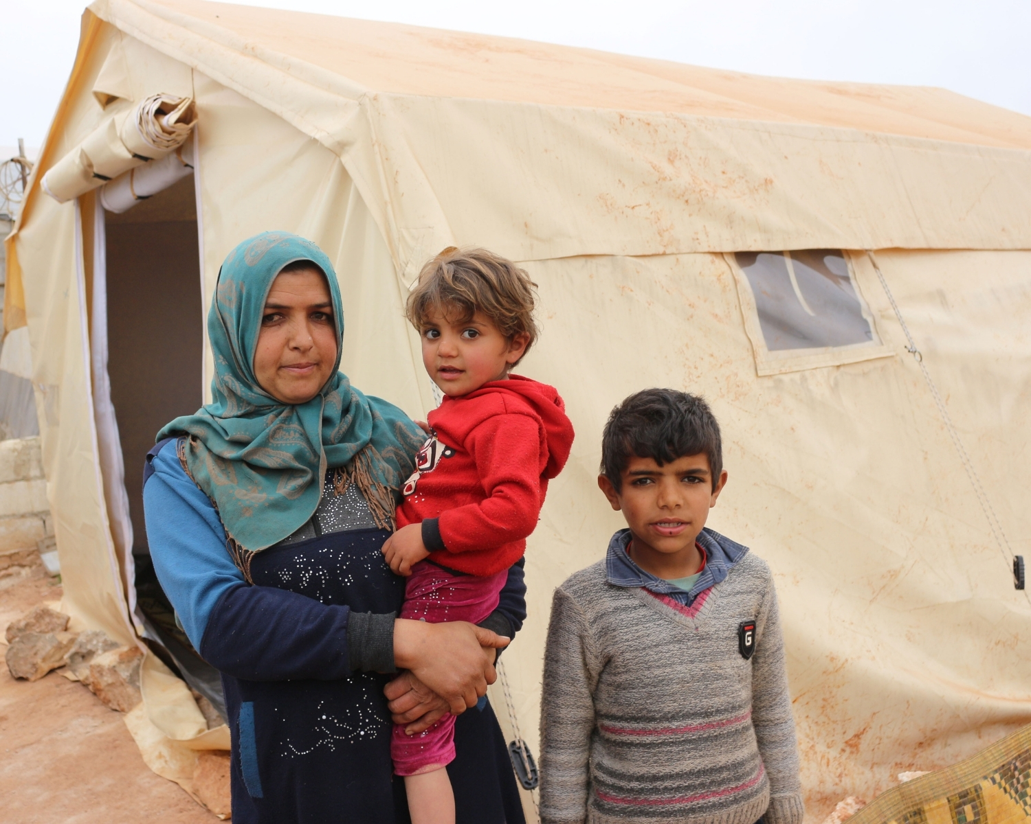 Syrian family outside tent