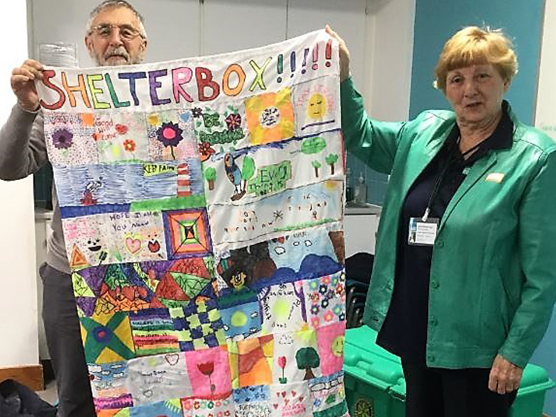 Above: Janet posing with a colorful work of art made by schoolchildren.