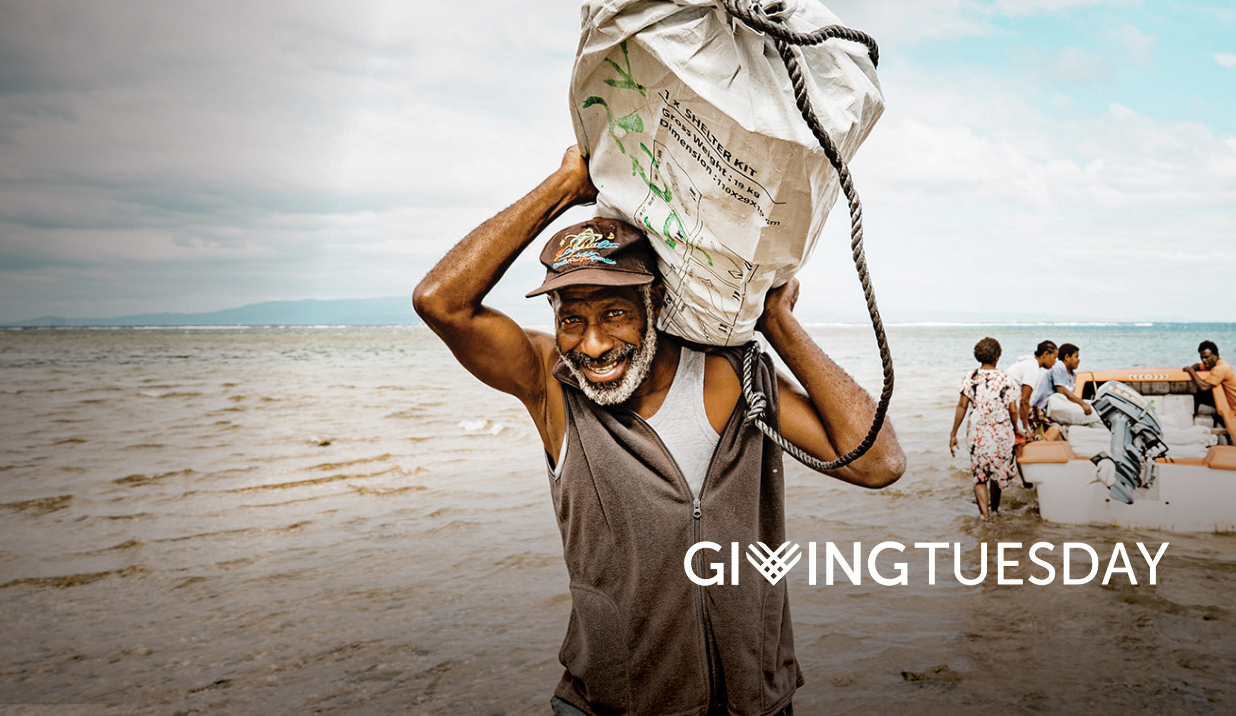 Man carries Shelter Kit across beach