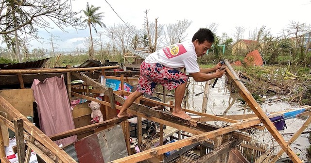 Filipino Man rebuilding after Typhoon Goni Rolly