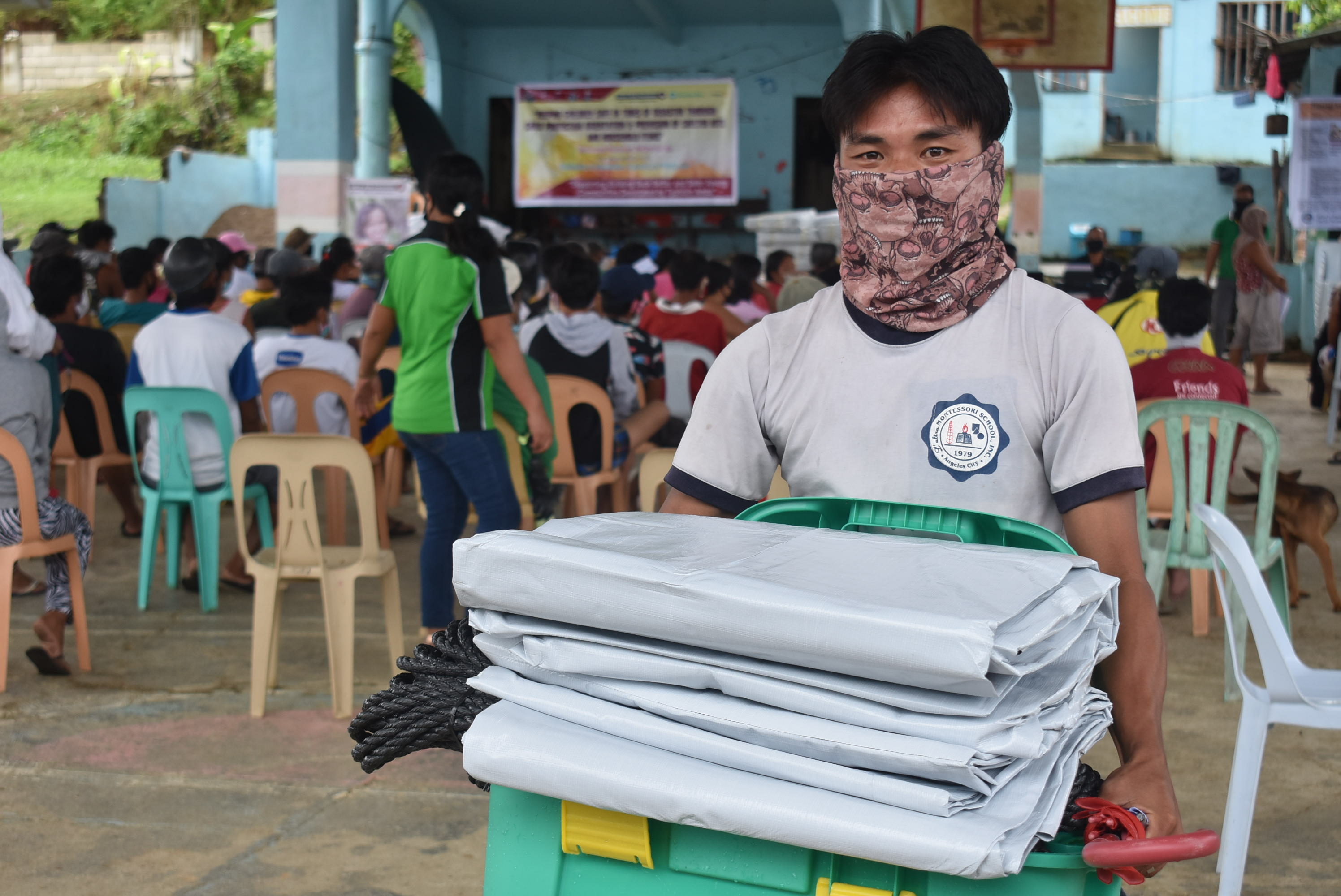 Alejandro wearing mask and carrying shelterbox