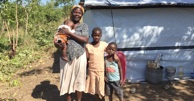 Grace and her family outside their tent