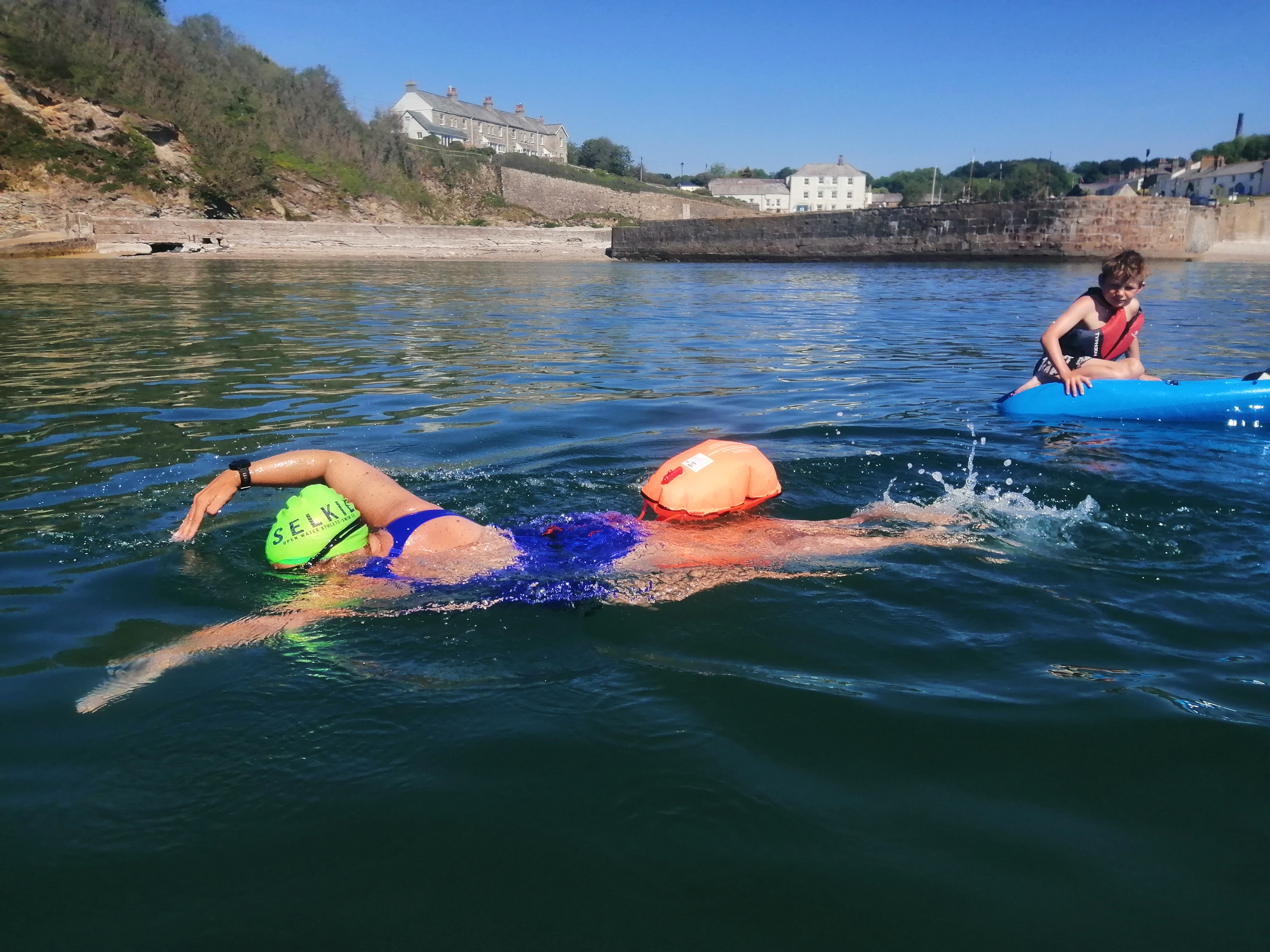 Lauren swimming with her son nearby in canoe