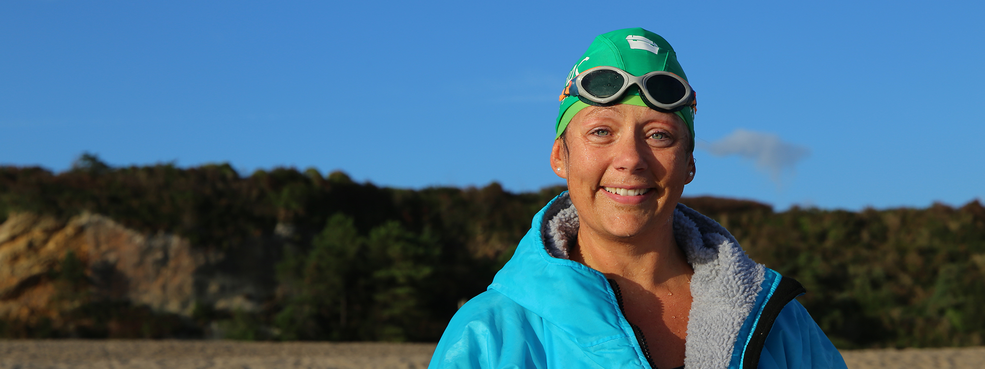 Lauren wearing swimming cap on beach