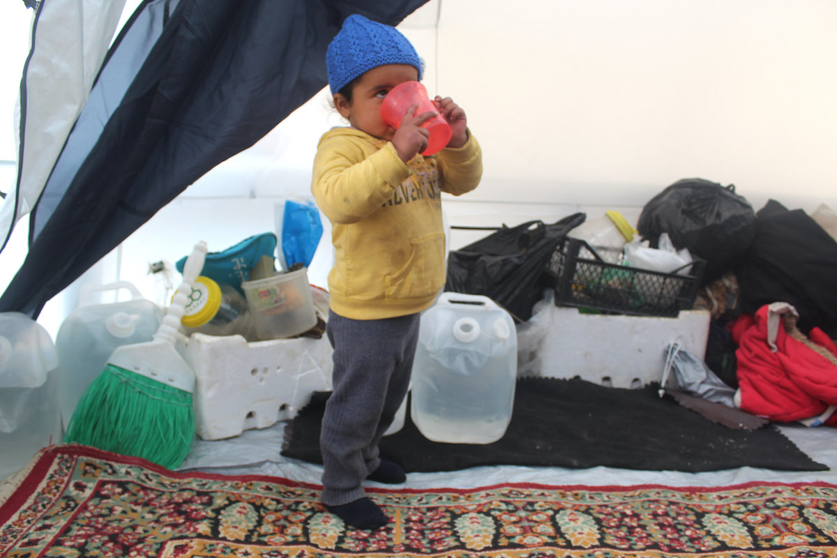 Young child enjoying a glass of water